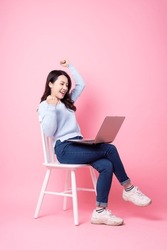 portrait of beautiful asian girl sitting in chair, isolated on pink background