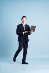 portrait of asian businessman wearing suit on blue background