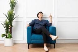 portrait of asian man sitting on sofa at home