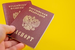 Russian passport, transliteration: Passport of the Russian Federation. A human hand with a Russian passport in close-up. The concept of obtaining citizenship of the Russian Federation. Close-up.