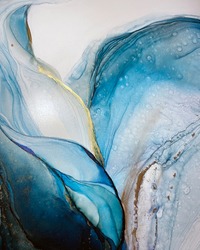 Abstract blue-green background with beautiful smudges and stains made with alcohol ink and gold pigment. Fragment of art with turquoise texture resembles watercolor or aquarelle painting.