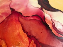 Abstract red background with yellow. Red fluid art texture made with alcohol ink. Beautiful smudges and stains. Bright backdrop resembles flower, petals, watercolor or aquarelle.