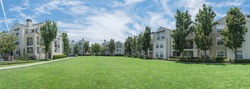 Panorama view apartment building complex with grassy backyard in Palo Alto, California, USA. Summer cloud blue sky