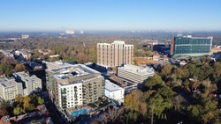Aerial view complex of apartment buildings, hotel and cooperate towers with swimming pool in Brookwood Hills neighborhood area surrounded by colorful fall foliage autumn leaves. Sunny clear blue sky