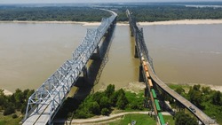 Old Vicksburg Bridge or Mississippi River Bridge with freight train crossing all-steel railroad truss river, a cantilever bridge carrying one rail line across the Mississippi River, USA. Aerial view