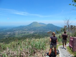 a couple of backpackers tourist enjoying the view of Tomohon from the Mahawu crater. This is one of a popular tourist object in Tomohon city, Manado, north Sulawesi Indonesia.  
