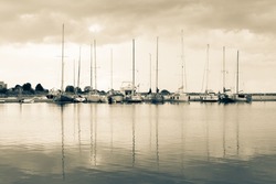 Photo of yacht harbor and water reflections. Horizontal seascape photography in split pastel tones.