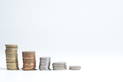 stacks of golden and silver coloured coins in decending order isolated in white background