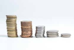 stacks of golden and silver coloured coins in decending order isolated in white background. selective focus