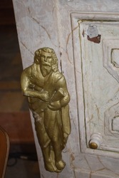Golden details in the form of human beings on a church pulpit 