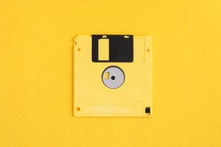 Yellow floppy diskette on yellow background