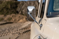 Close-up of a vintage car door handle on a beach.