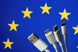 Concept for new EU legislation on USB-C universal charging cable. EUROPEAN UNION flag and different charging cables such as USB, USB-C, Micro USB, lightning cable. 