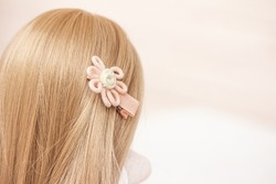 Kids' hair accessories, safe hairclips for toddlers. A soft hair clip in the hair of a blonde girl, copy space right. Hair accessory Top view