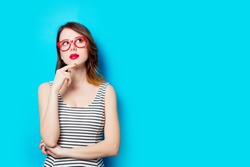 portrait of beautiful young woman in glasses on the wonderful blue studio background