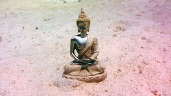 buda statue on the red sea sand bottom