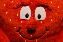 Plush red mascot with a smile and big eyes.