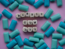 Bubble gum day. Colored bubble gum background with text Bubble Gum Day. Blue and green pads of chewing gum on pink background.