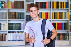 Portrait of male teenage student looking into the camera in library