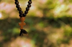 Rosary with wooden cross in nature. Concept for faith, spirituality and religion.