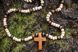 Rosary with wooden cross in nature. Concept for faith, spirituality and religion.