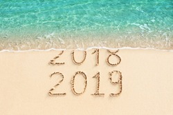 New Year 2018 change to 2019. Sand beach and blue ocean wave. 