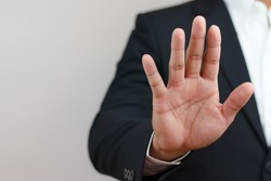 businessman raising his hand in front indicating order to stop, forbid, invalid. Corruption, illegal, anti-corruption concept.