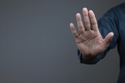 man showing stop gesture reject on black background with empty space for text, copy space, close up of the hand, anti concept, rejection
