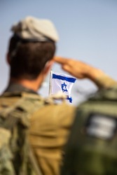 IDF officer saluting the Israeli flag