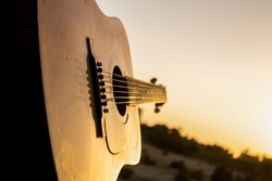 Acoustic guitar during sunset. Playing guitar during sunset. Guitar and sunset. Playing music with friends before the sun has set.