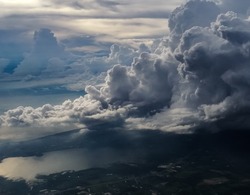 huge storm cloud, tower cumulus and cumulonimbus cloud, develop over sea and lake at dawn