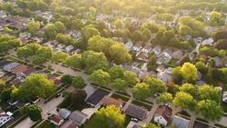 Aerial view of american suburb at summertime.  Establishing shot of american neighborhood. Real estate, residential houses. Drone shot, from above