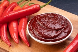 Korean pepper paste and red pepper in wooden plate, Gochujang Korean traditional Chili paste on a wooden table background.