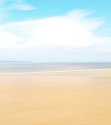 Rising tide, sand, water and sky with blur effect, ICM photography