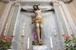 Statue of Jesus in the church of San Nicola in prison, Rome. Wooden crucifix on the decorated wall.
