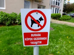 No dogs allowed sign in Turkish in a garden, Dog prohibited. Warning, road sign, no pets sign, prohibition, forbidden circle, crossed out red circle, ban symbol