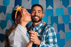 Brazilian June Festival, romantic woman kissing boyfriend at Festa Junina in Brazil in traditional clothes