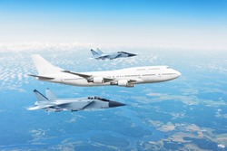 Large passenger plane, accompanied by two military fighter. Concept of airborne danger, air force