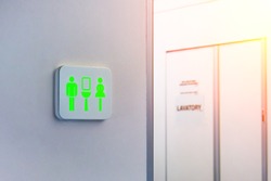 Not occupied toilet sign is marked in green, against the background is a door from the wc inside the plane