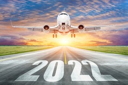 The inscription on the runway 2022 surface of the airport runway with take off airplane. Concept of travel in the new year, holidays