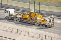 Excavator loaded on a trailer for heavy equipment. heavy transport truck.