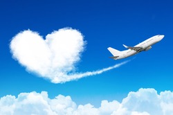 Airplane in the blue sky with clouds, left a trace in the form of a cloud of the heart