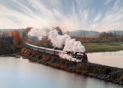 Vintage steam locomotive train in the autumn landscape.