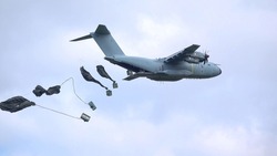 ZM401 RAF Royal Air Force Airbus A400M Atlas military cargo plane on a low-level cargo parachute drop exercise, blue sky light cloud