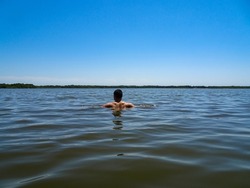 Young swimmer swimming in the blue lake in France                 