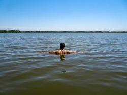 Young swimmer swimming in the blue lake in France                