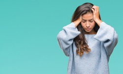 Young beautiful arab woman wearing winter sweater over isolated background suffering from headache desperate and stressed because pain and migraine. Hands on head.