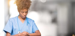 Young african american doctor woman over isolated background Checking the time on wrist watch, relaxed and confident