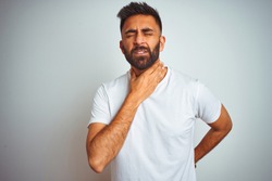Young indian man wearing t-shirt standing over isolated white background Touching painful neck, sore throat for flu, clod and infection