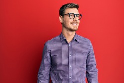 Handsome caucasian man wearing business shirt and glasses looking to side, relax profile pose with natural face and confident smile. 